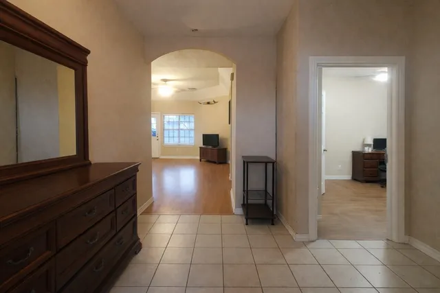 a view of a hallway with wooden floor and a bathroom