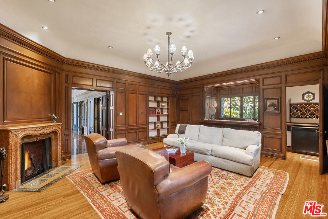 710 North Maple Drive Beverly Hills, CA 90210 - Photo 7 of 18 a living room with furniture a fireplace and a chandelier
