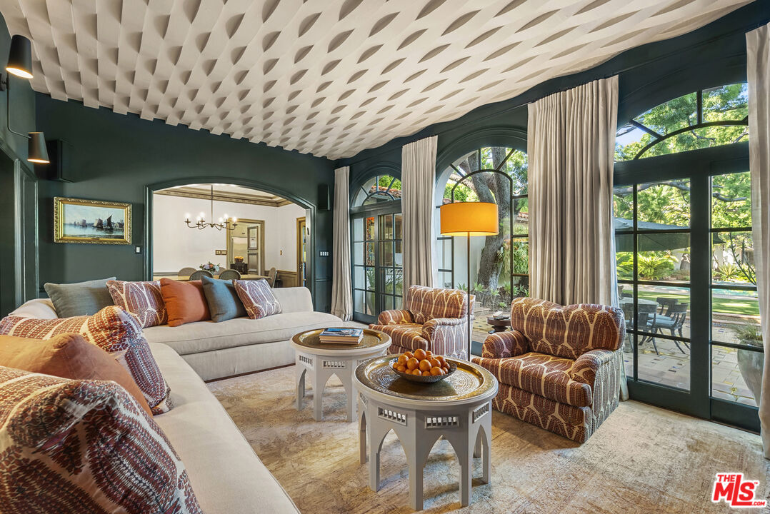 710 North Maple Drive Beverly Hills, CA 90210 - Photo 8 of 18 a living room with furniture and a large window with garden view