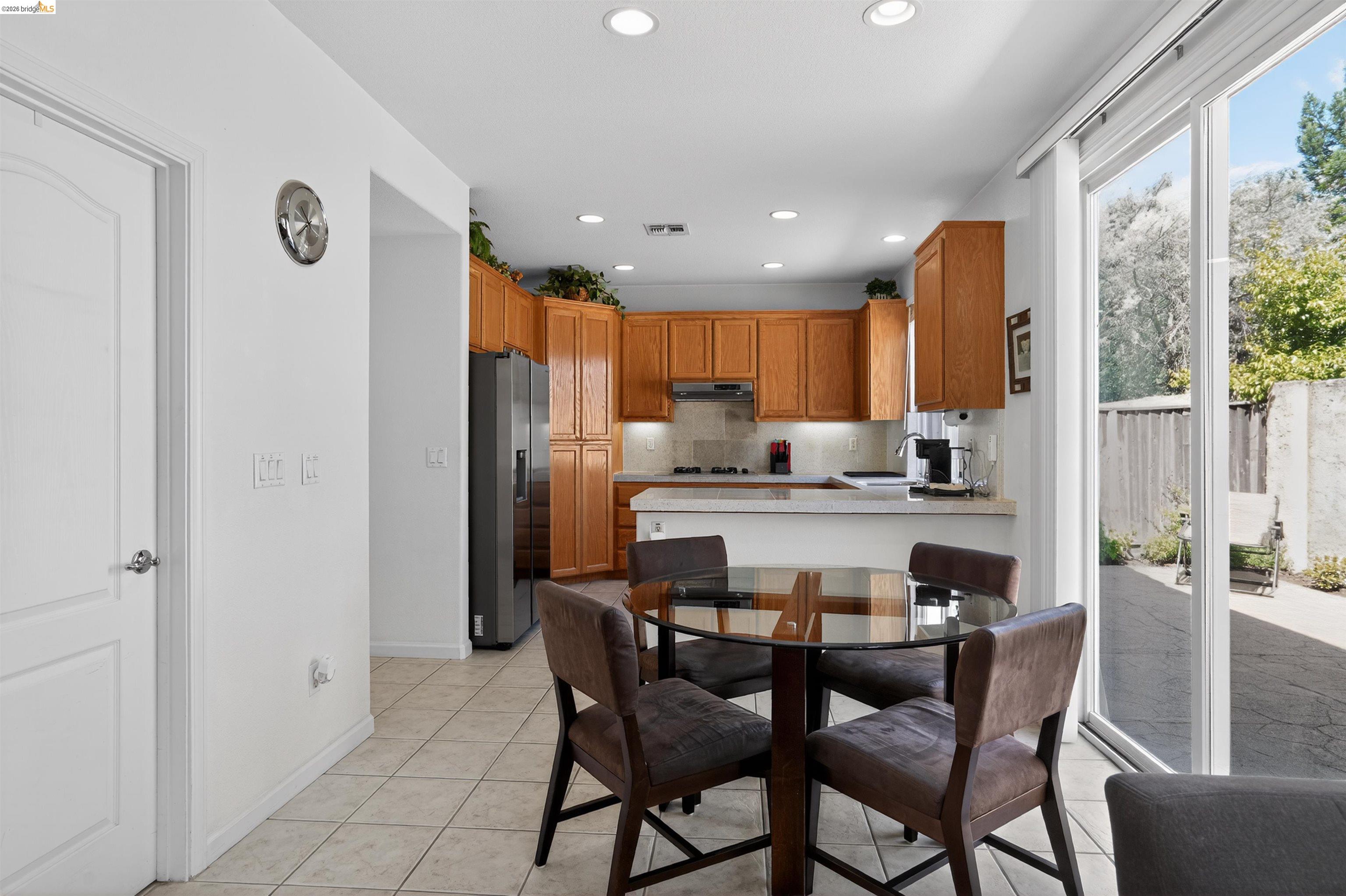 1221 Andrea Way Vallejo, CA 94591 - Photo 11 of 29 Kitchen and dining area featuring light wood cabinetry, recessed lighting, tile flooring, and a sliding glass door providing access to the exterior