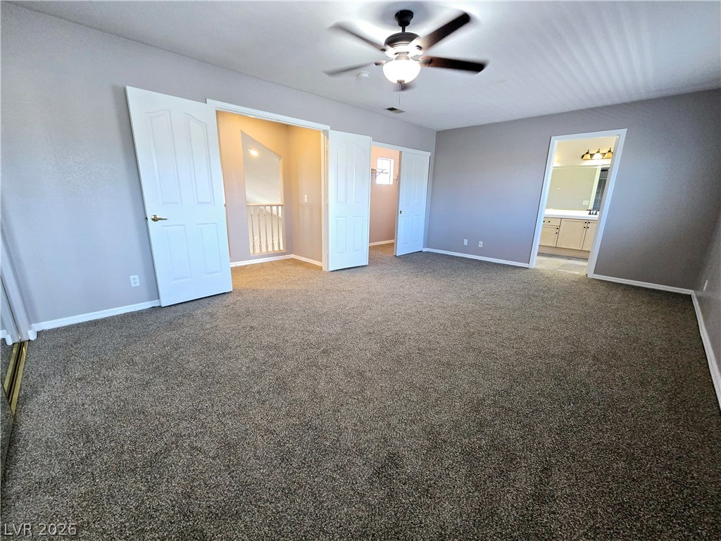 3759 Funston Way Las Vegas, NV 89129 - Photo 6 of 31 A spacious primary bedroom featuring plush carpeting, a ceiling fan, and convenient access to a private bathroom.