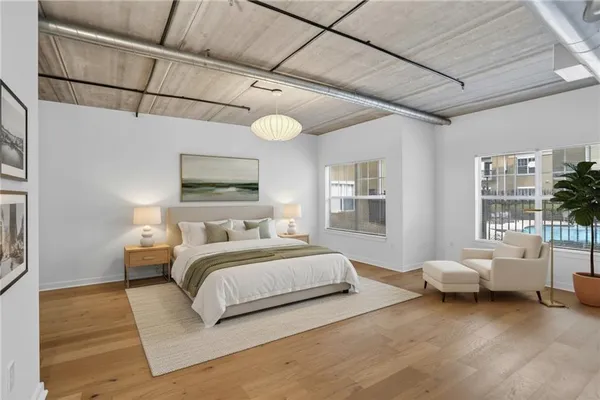 a spacious bedroom with a bed couch and a window