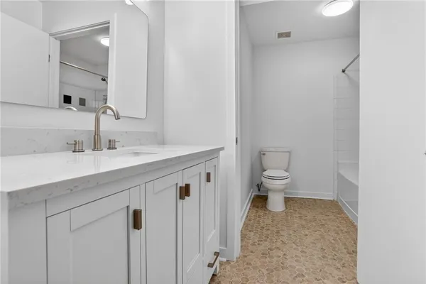 a bathroom with a sink a toilet and a mirror
