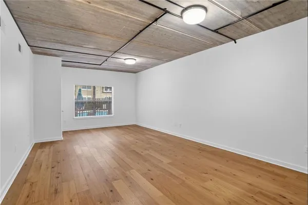a view of empty room with wooden floor