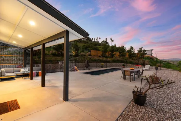 a view of a house with swimming pool and sitting area