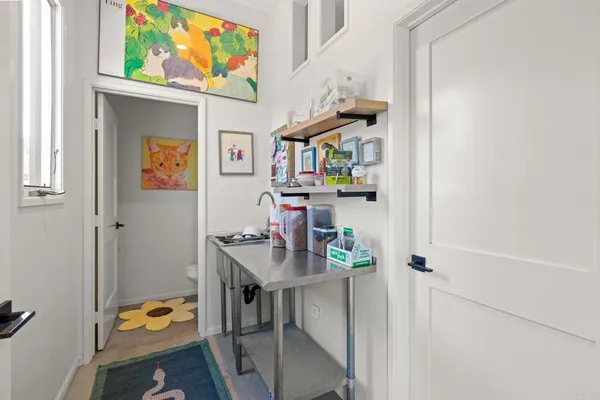 a room with stainless steel appliances kitchen island granite countertop a refrigerator a sink dishwasher a dining table and chairs with wooden floor