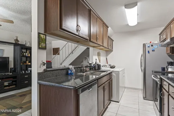 a kitchen with stainless steel appliances granite countertop a sink a stove and a refrigerator