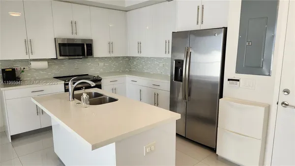 a kitchen with stainless steel appliances a refrigerator sink and microwave