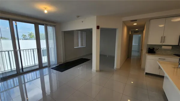 a view of a refrigerator in kitchen and a window