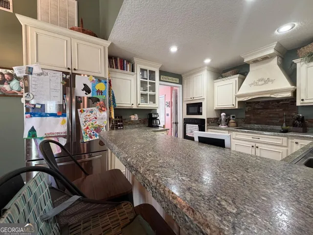 a kitchen with stainless steel appliances a stove a sink a microwave and cabinets