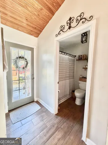 a view of a hallway with wooden door and entryway