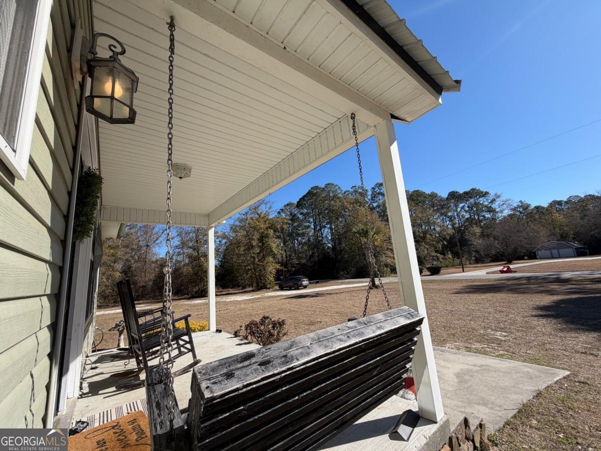 3231 Pear Avenue Patterson, GA 31557 - Photo 3 of 43 a view of a patio with table and chairs with wooden floor and fence