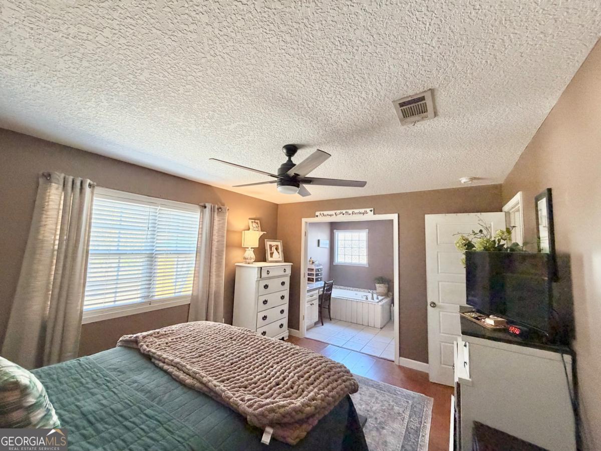 3231 Pear Avenue Patterson, GA 31557 - Photo 32 of 43 a bedroom with a bed a large window and furniture