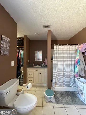 a spacious bathroom with a granite countertop sink and a mirror