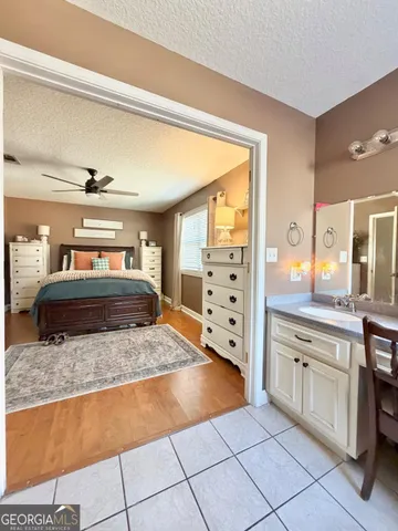 a bedroom with a bed chandelier and a window
