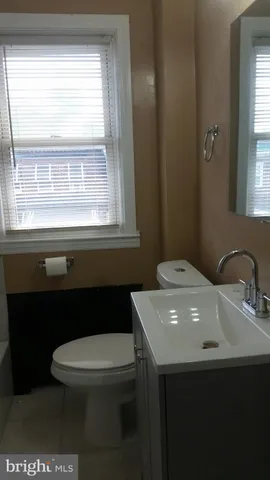 a bathroom with a sink a toilet and a window