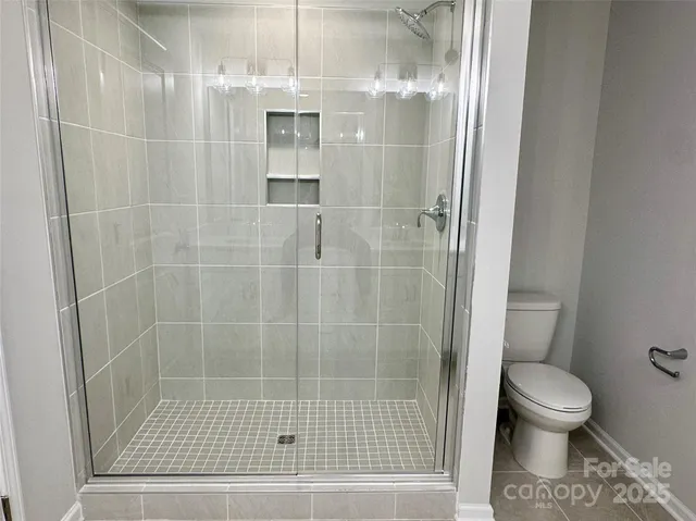 a bathroom with a toilet and a shower