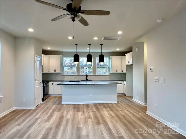 a large kitchen with kitchen island a sink stainless steel appliances and cabinets