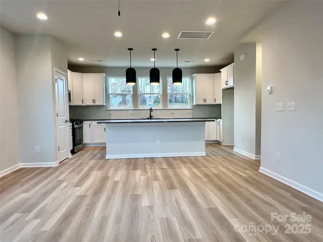 a view of kitchen with cabinets microwave and stove