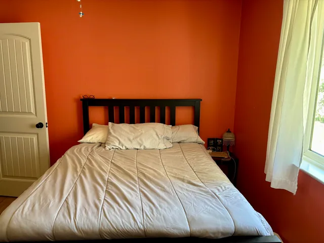a bed sitting in a bedroom next to a window