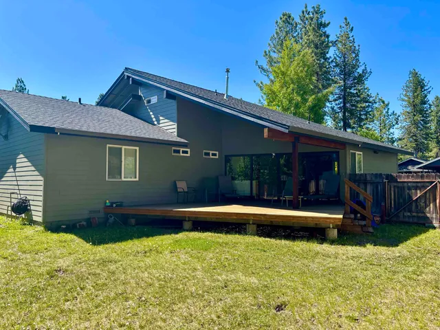 a backyard of a house with a yard patio and wooden fence