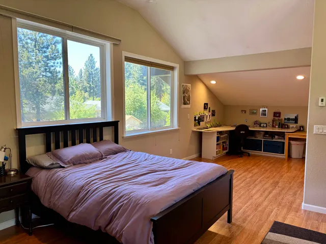 a bedroom with a bed and large windows