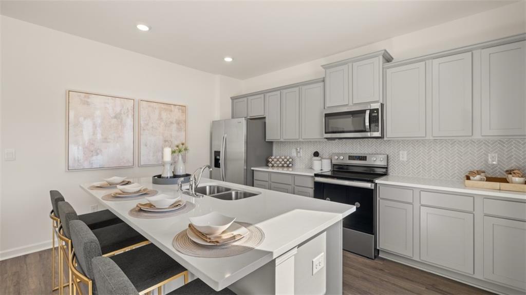 182 Aster Avenue Locust Grove, GA 30248 - Photo 12 of 48 a view of kitchen with sink dining table and chairs