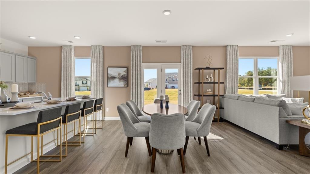 182 Aster Avenue Locust Grove, GA 30248 - Photo 16 of 48 a view of a dining room with furniture window and wooden floor