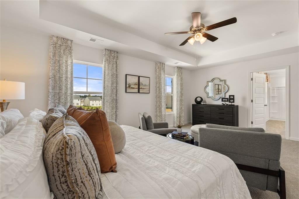 182 Aster Avenue Locust Grove, GA 30248 - Photo 25 of 48 a bedroom with a bed a couch and a chandelier