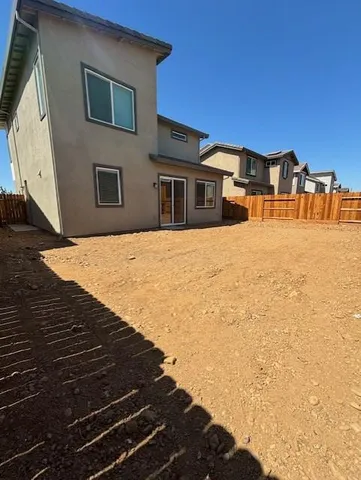 a backyard of a house with wooden fence