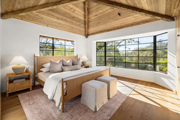 a spacious bedroom with a bed and a large window