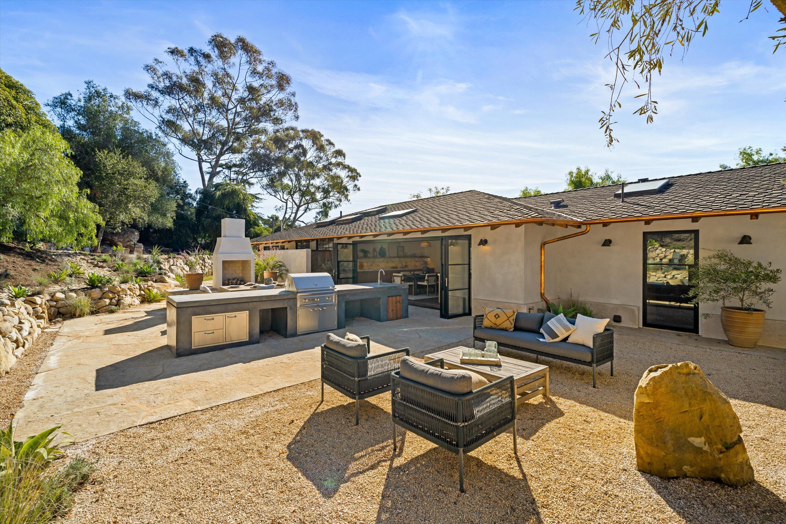 734 El Rancho Road Montecito, CA 93108 - Photo 18 of 24 a view of a patio with couches table and chairs under an umbrella