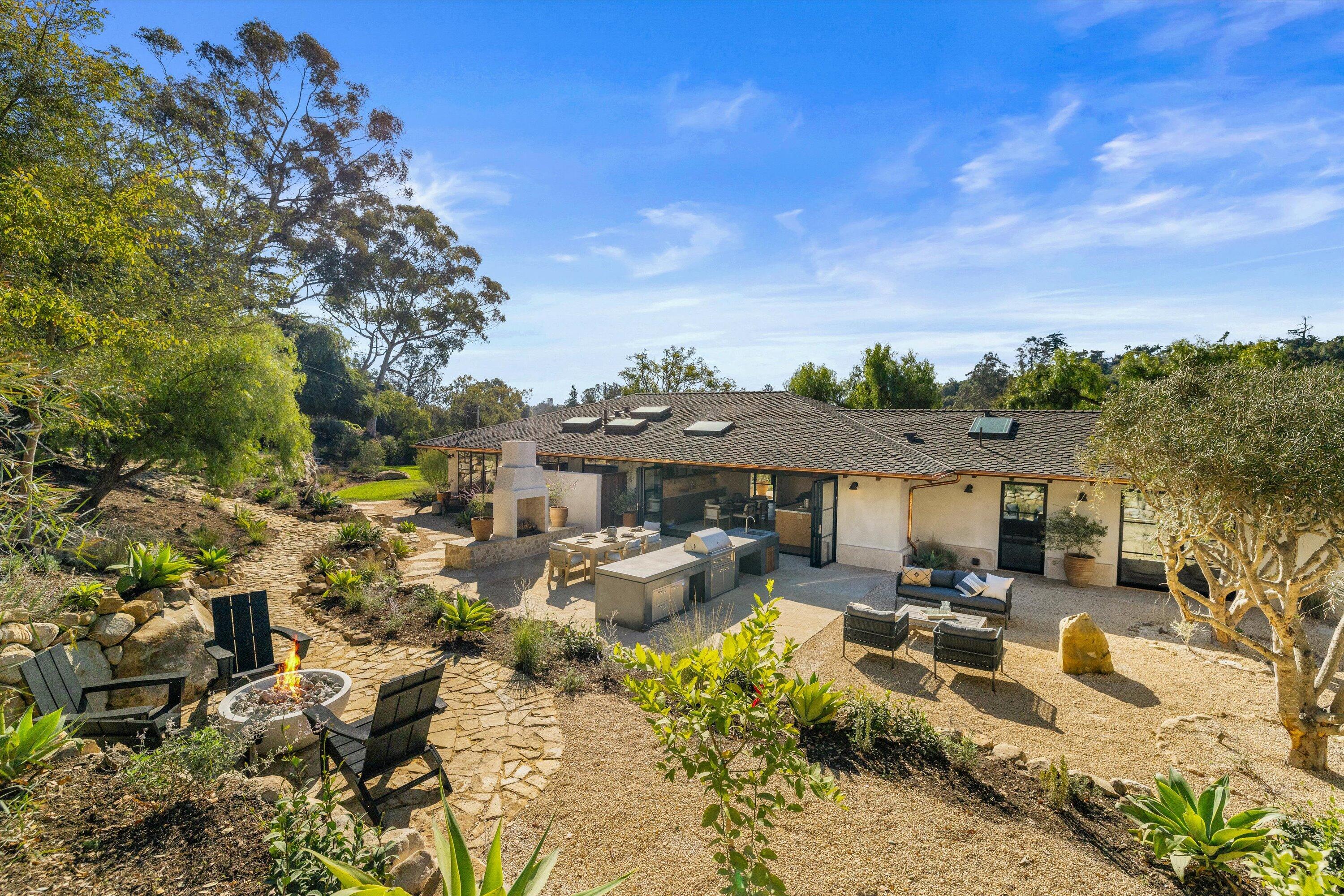 734 El Rancho Road Montecito, CA 93108 - Photo 22 of 24 a view of a patio with couches table and chairs under an umbrella