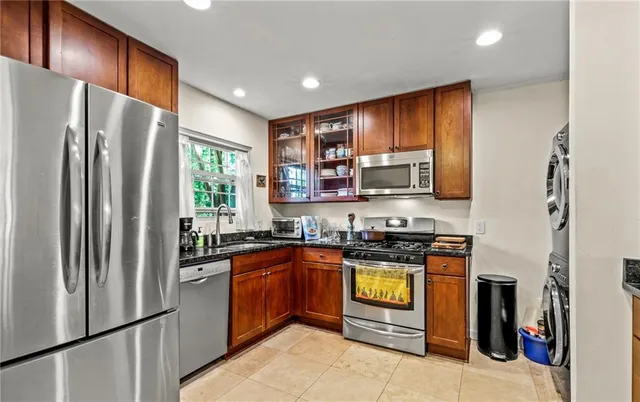 a kitchen with stainless steel appliances granite countertop a refrigerator a stove top oven a sink and dishwasher