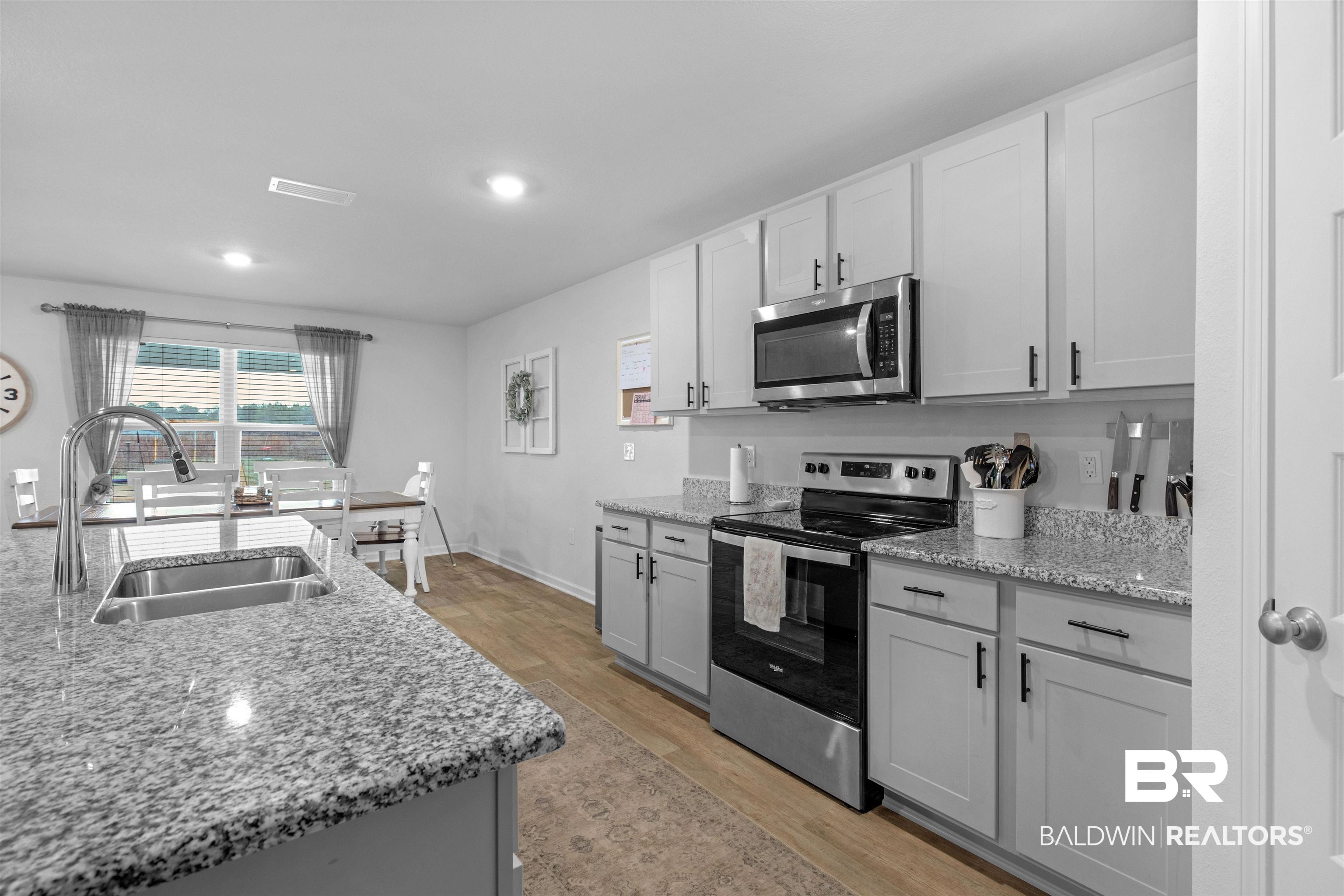 10313 Ruffian Route Daphne, AL 36526 - Photo 21 of 46 Kitchen with sink, gray cabinetry, light wood-type flooring, stainless steel appliances, and light stone countertops