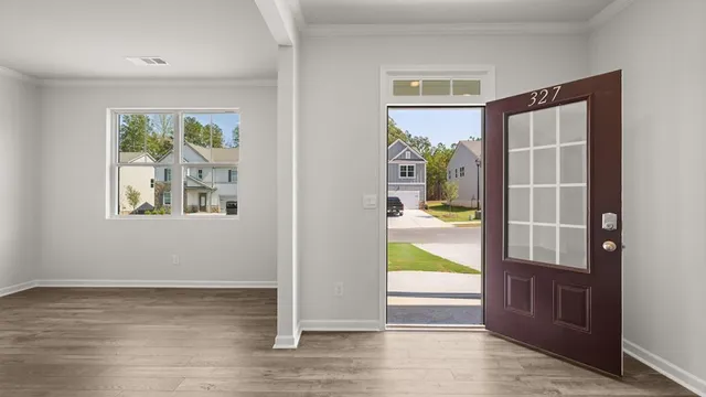 an empty room with wooden floor and windows