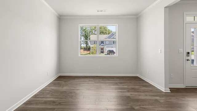 a view of a hallway with wooden floor and a bathroom