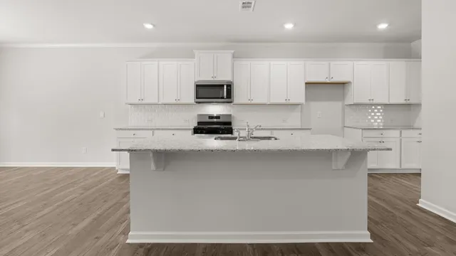 a kitchen with white cabinets and appliances