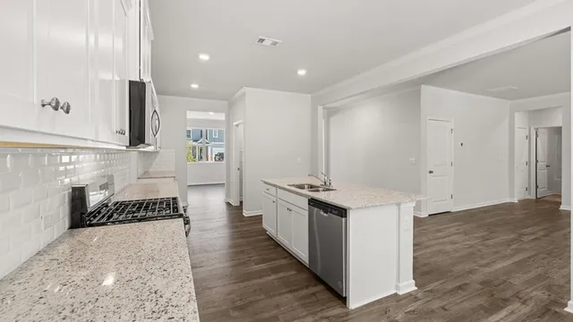 a kitchen with granite countertop a sink stainless steel appliances and cabinets