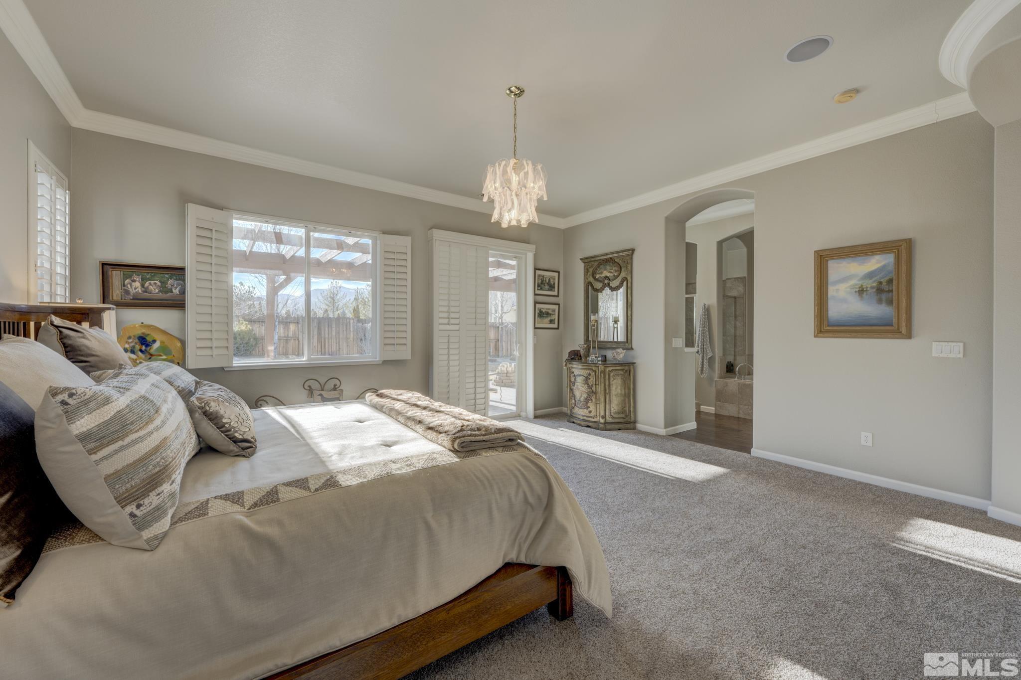 10585 Dillingham Drive Reno, NV 89521 - Photo 20 of 39 a bedroom with a large bed and a chandelier