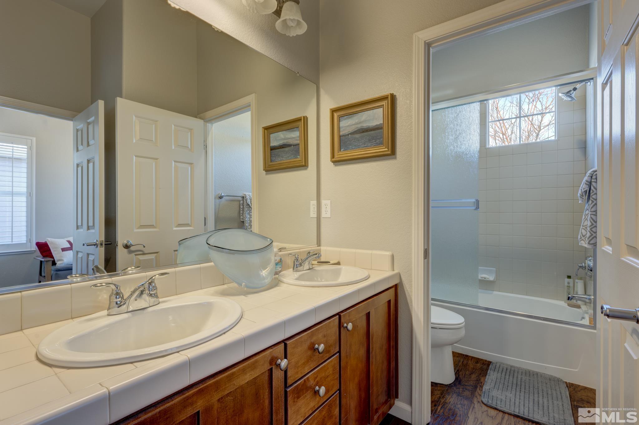 10585 Dillingham Drive Reno, NV 89521 - Photo 28 of 39 a bathroom with a double vanity sink toilet mirror and bathtub