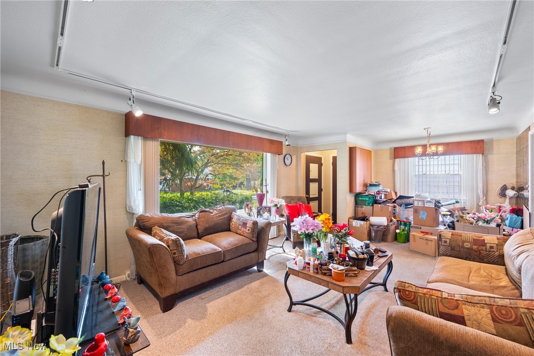 920 Clinton Avenue Cleveland, OH 44121 - Photo 8 of 14 Carpeted living room with a textured ceiling and a chandelier