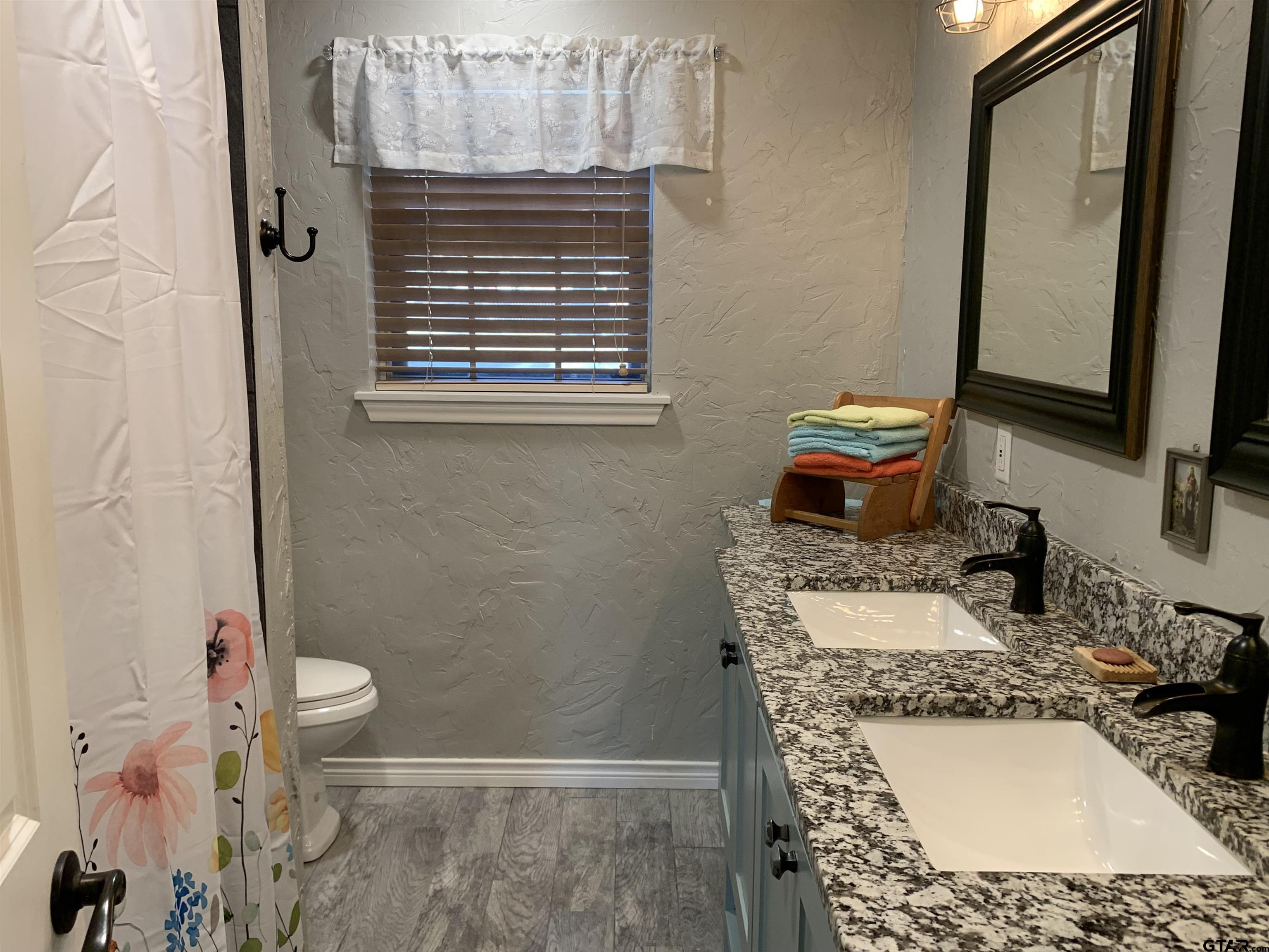 800 Neches Drive Tyler, TX 75702 - Photo 14 of 26 a bathroom with a granite countertop sink and a mirror