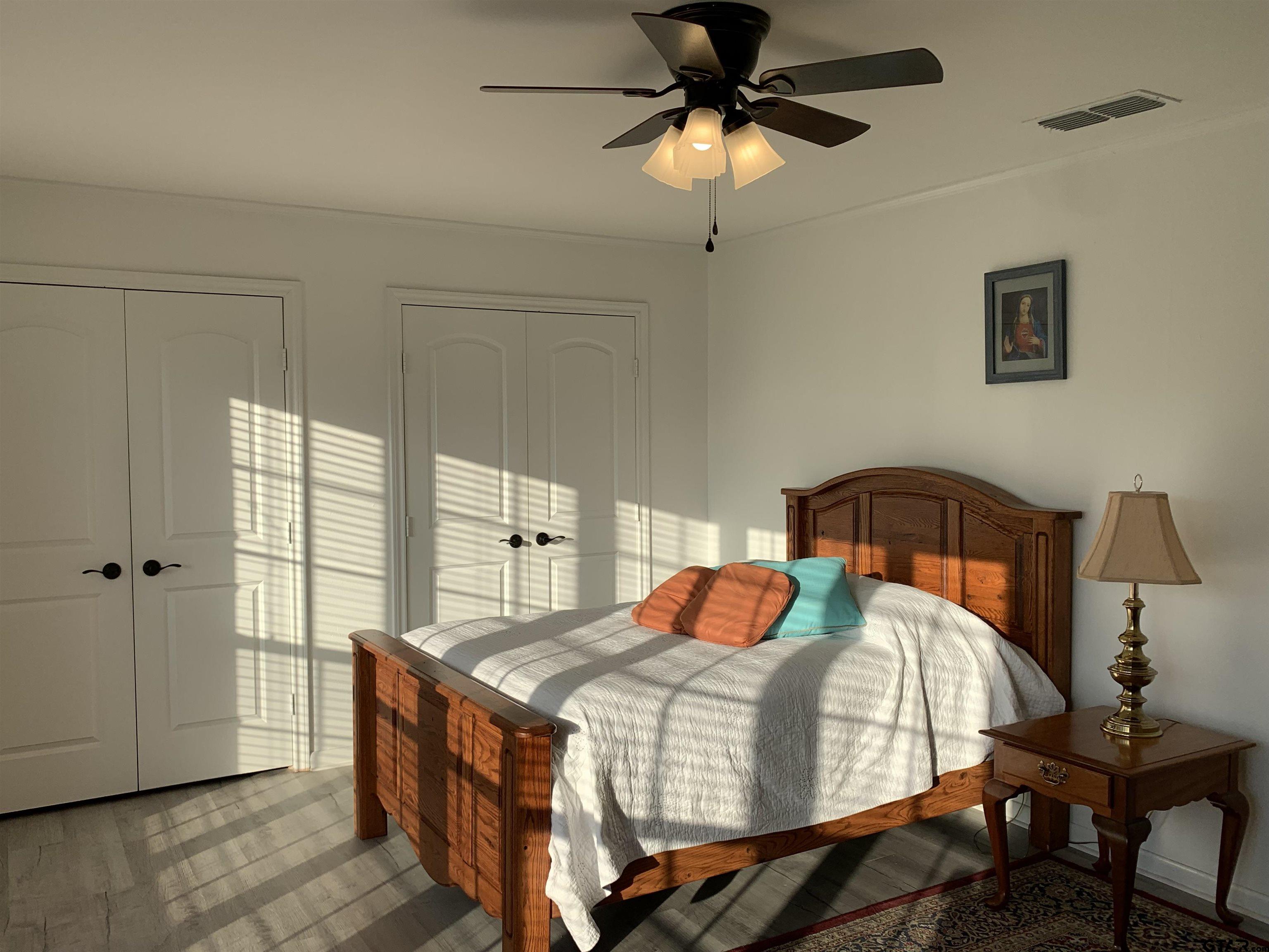 800 Neches Drive Tyler, TX 75702 - Photo 17 of 26 a bedroom with a bed and a chandelier