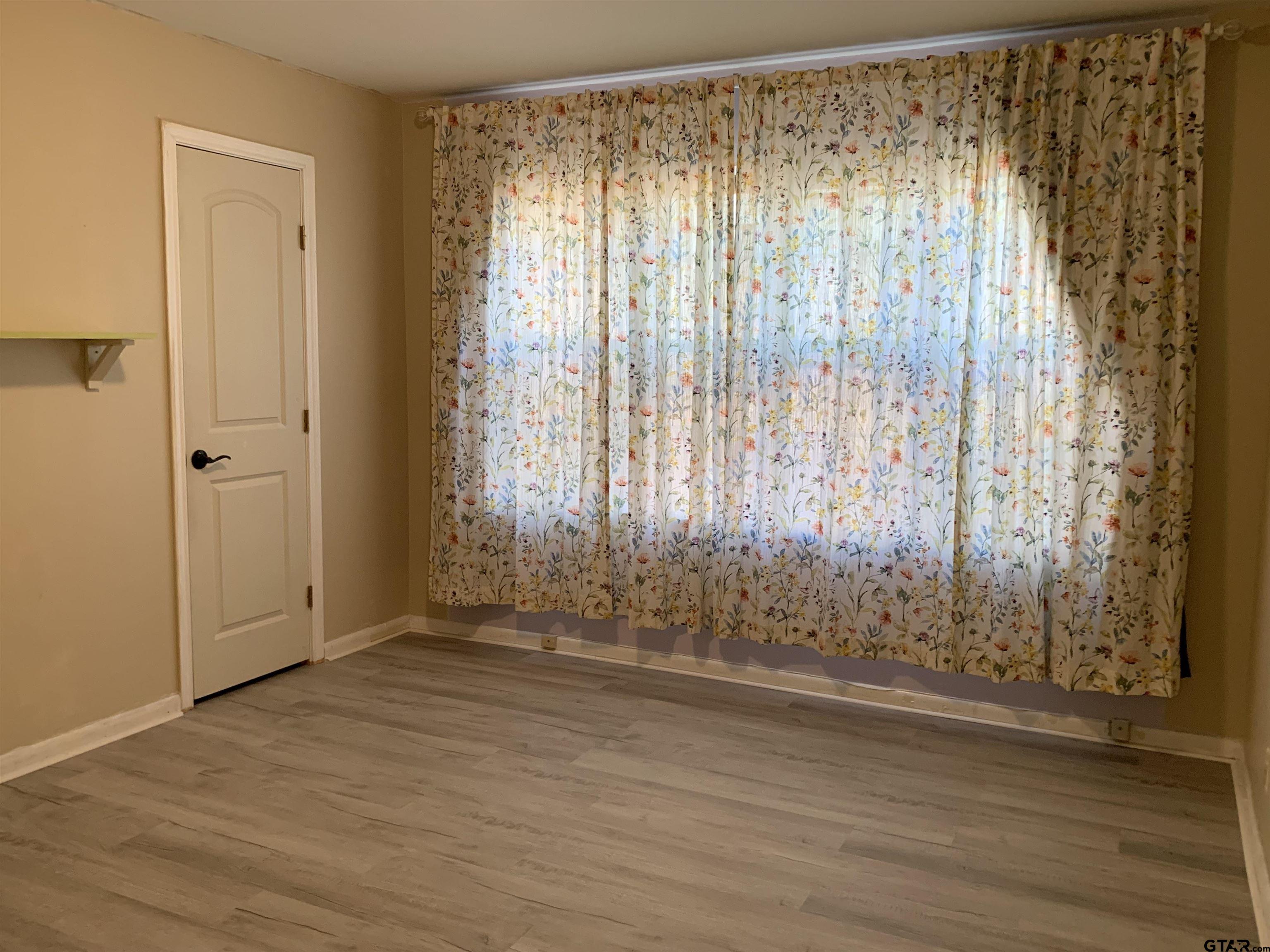 800 Neches Drive Tyler, TX 75702 - Photo 19 of 26 an empty room with wooden floor and a window