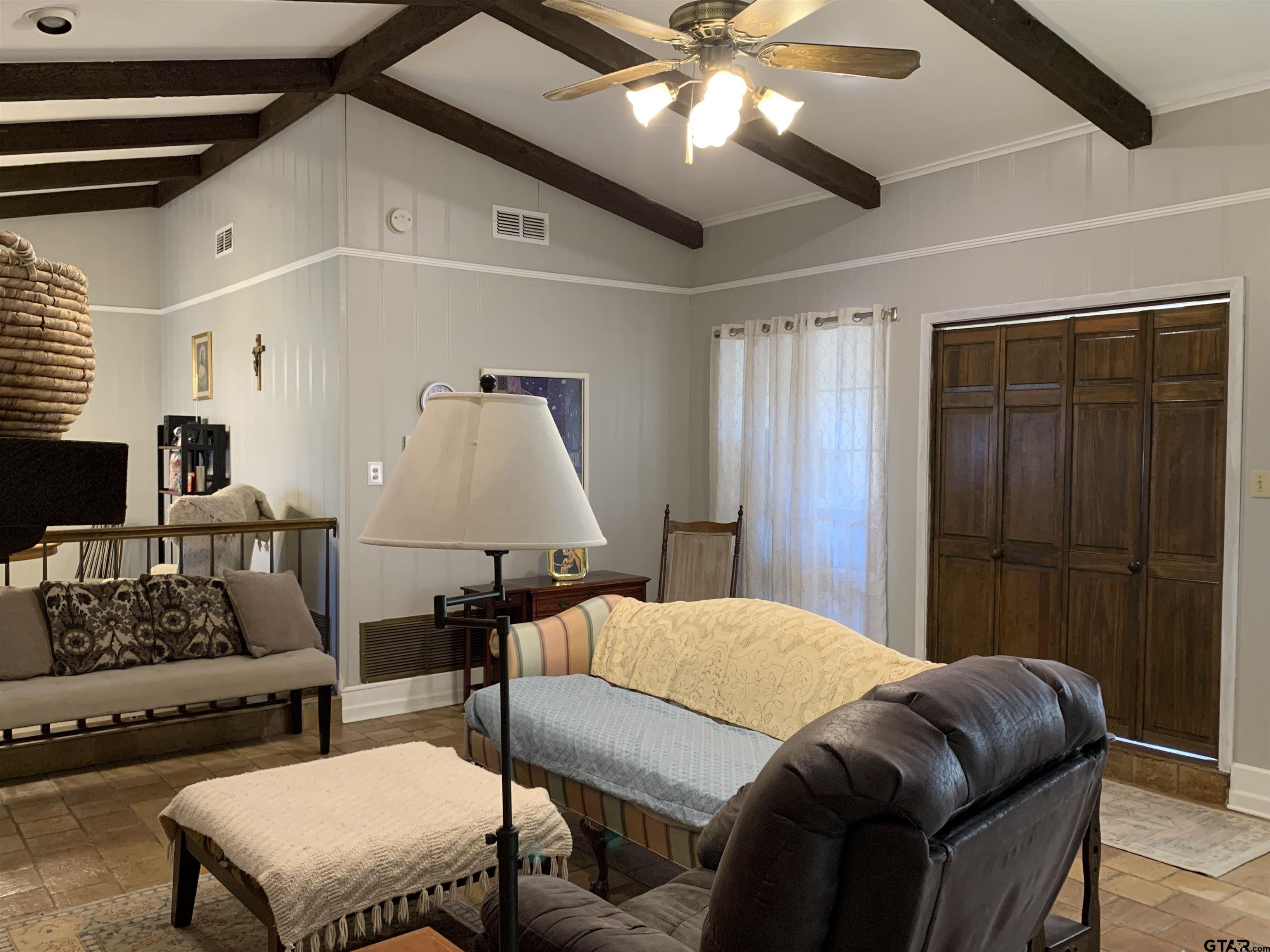 800 Neches Drive Tyler, TX 75702 - Photo 7 of 26 a bedroom with a bed a couch and a ceiling fan