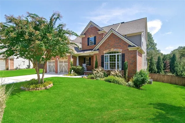 a front view of a house with a yard and trees