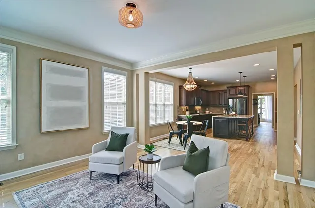 a living room with furniture a fireplace and a chandelier