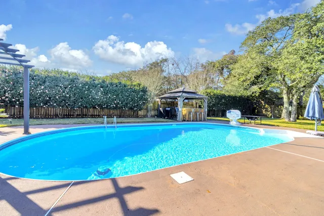 a view of a swimming pool with couches and wooden floor