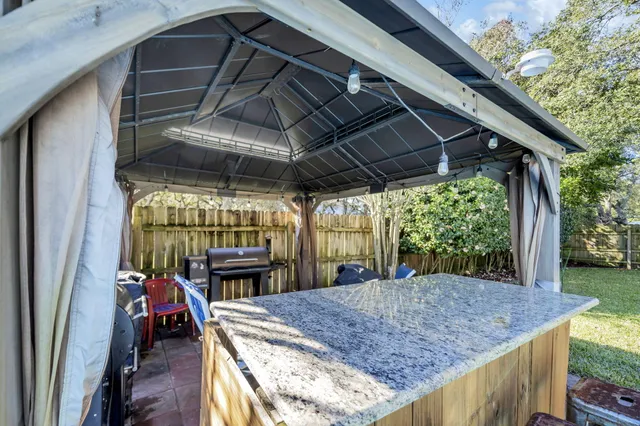 a view of a patio with table and chairs under an umbrella